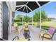 The screened lanai features comfortable seating with a relaxing view of the backyard at 2348 Riley Rd, The Villages, FL 32162