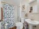 Clean bathroom showcasing a tub with nautical shower curtain, toilet and pedestal sink at 239 Juniper Way, Tavares, FL 32778