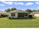 Rear exterior view of a home featuring a covered patio and well-maintained lawn at 239 Juniper Way, Tavares, FL 32778