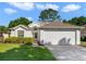 Charming single-story home featuring a well-manicured lawn, attached garage, and inviting front entrance at 239 Juniper Way, Tavares, FL 32778
