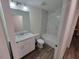 Stylish bathroom with marble vanity, white cabinets, and a tiled shower-tub combo at 254 Locust Pass Dr, Ocala, FL 34472