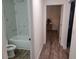Bathroom leading to bedroom hallway featuring toilet, tub, and tiled shower at 254 Locust Pass Dr, Ocala, FL 34472