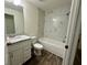 Well-lit bathroom with marble-look shower, modern vanity, and wood-look flooring at 254 Locust Pass Dr, Ocala, FL 34472