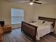 Comfortable bedroom featuring wood-look floors, a ceiling fan, and a bright window at 254 Locust Pass Dr, Ocala, FL 34472
