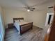 Bright bedroom with ceiling fan and wood-look floors, leading to closet and hallway at 254 Locust Pass Dr, Ocala, FL 34472