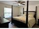 Comfortable main bedroom with a four-poster bed, ceiling fan, and natural light from the window at 254 Locust Pass Dr, Ocala, FL 34472