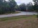 Street view of intersection, with street signs, road and some trees in the background at 254 Locust Pass Dr, Ocala, FL 34472