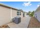 Rear view showcasing the home's back exterior, HVAC, and landscaped yard at 2564 Red Cedar Ln, The Villages, FL 32162