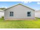 Backyard of home featuring well-kept lawn and beige siding on the home's exterior at 2564 Red Cedar Ln, The Villages, FL 32162