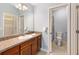 Bathroom with vanity, large mirror, wood cabinets and a door to a shower and toilet room at 2564 Red Cedar Ln, The Villages, FL 32162