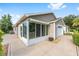 Rear view of the property featuring a large patio, attached two car garage and rear screened in porch at 2564 Red Cedar Ln, The Villages, FL 32162