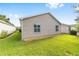 Exterior view of a home showing a green lawn and beige horizontal siding on the house at 2564 Red Cedar Ln, The Villages, FL 32162