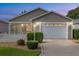 Front elevation view of house with manicured lawn, trimmed bushes, and an attached garage at 2564 Red Cedar Ln, The Villages, FL 32162