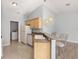 Galley kitchen featuring light wood cabinets, granite counters, and stainless steel appliances at 2564 Red Cedar Ln, The Villages, FL 32162