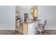 Galley kitchen featuring light wood cabinets, granite counters, and stainless steel appliances at 2564 Red Cedar Ln, The Villages, FL 32162