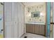 Bathroom featuring a floral-themed wallpaper, a vanity with wooden cabinets, and a large storage closet at 2706 Vindale Rd, Tavares, FL 32778