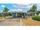 Charming single-story home featuring a covered parking area and a beautifully landscaped front yard with blue accents at 2706 Vindale Rd, Tavares, FL 32778