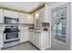 This kitchen features white cabinets and appliances, a decorative backsplash, and a door leading to the outside at 2706 Vindale Rd, Tavares, FL 32778