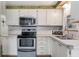 This kitchen features white cabinets, stainless steel appliances and a decorative backsplash, with lots of counter space at 2706 Vindale Rd, Tavares, FL 32778