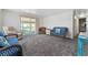 Cozy living room with plush carpeting, neutral walls, and comfortable seating with sliding glass door to outside at 2706 Vindale Rd, Tavares, FL 32778