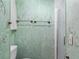 Green-toned shower room featuring a shower with glass doors and decorative wall accents at 2706 Vindale Rd, Tavares, FL 32778