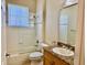 Well-lit bathroom with a granite countertop vanity and shower-tub combination at 3083 Pinnacle Ct, Clermont, FL 34711