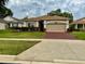 Charming single-story home with a well-maintained lawn and a brick-paved driveway at 3083 Pinnacle Ct, Clermont, FL 34711