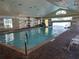 Community indoor pool with a vaulted ceiling, ceiling fans, and natural light at 3083 Pinnacle Ct, Clermont, FL 34711