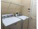 Practical laundry room with modern white washer and dryer, plus storage shelves at 3083 Pinnacle Ct, Clermont, FL 34711