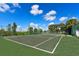Well-maintained tennis court under a sunny sky surrounded by lush landscaping at 3107 Sun Lake Ct # A, Kissimmee, FL 34747