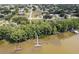 Aerial view of docks along a tree-lined lakefront with homes visible in the distance at 3141 Brighton Rd, Eustis, FL 32726