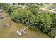 Aerial view featuring docks on the lake with surrounding trees and residential areas in the distance at 3141 Brighton Rd, Eustis, FL 32726
