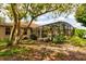 Landscaped backyard showing screened-in pool, trees and foliage, with a partial view of the exterior of the home at 3141 Brighton Rd, Eustis, FL 32726