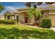 Welcoming front entrance with stone pillars, a red door, and a meticulously maintained lawn at 3141 Brighton Rd, Eustis, FL 32726