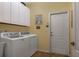 Laundry room featuring a washer, a dryer, white cabinets, and a tile floor at 3141 Brighton Rd, Eustis, FL 32726