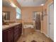 Main bathroom featuring double sinks, a shower, a bathtub, a tile floor, and dark wood cabinets at 3141 Brighton Rd, Eustis, FL 32726
