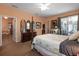 Well-lit main bedroom with carpet, ceiling fan, dresser with mirrors, and sliding doors to the outside at 3141 Brighton Rd, Eustis, FL 32726
