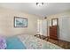 Comfortable bedroom featuring a floral bed, dresser and closet, with wood look tile floor at 33637 E Lake Joanna Dr, Eustis, FL 32736