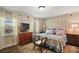 Cozy bedroom featuring windows with stained glass, dresser and comfortable bed with floral bedding at 33637 E Lake Joanna Dr, Eustis, FL 32736