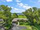 Beautiful waterfront property featuring lush landscaping, mature trees, and an expansive lawn leading to the water at 33637 E Lake Joanna Dr, Eustis, FL 32736