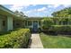 Welcoming entrance with a vibrant blue door, decorative wreath, and lush, green landscaping at 33637 E Lake Joanna Dr, Eustis, FL 32736