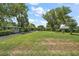 Well-manicured front yard with mature trees, enhancing the curb appeal of the home at 33637 E Lake Joanna Dr, Eustis, FL 32736