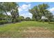 Well-manicured front yard with mature trees, enhancing the curb appeal of the home at 33637 E Lake Joanna Dr, Eustis, FL 32736