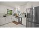 Modern kitchen with stainless steel appliances, white cabinetry and countertops, and tile flooring at 33637 E Lake Joanna Dr, Eustis, FL 32736