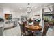 Bright kitchen and breakfast nook featuring white cabinetry, stainless steel appliances, and a charming light fixture at 33637 E Lake Joanna Dr, Eustis, FL 32736