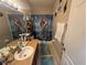 Cozy bathroom with a single sink vanity, unique mermaid-themed shower curtain, and neutral tile flooring at 33818 Venice Ln, Sorrento, FL 32776