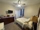 Comfortable bedroom with a ceiling fan, dresser, and natural lighting at 33818 Venice Ln, Sorrento, FL 32776