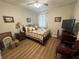 Charming bedroom with wood floors, comfortable bed, and natural light from the window at 33818 Venice Ln, Sorrento, FL 32776