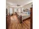 Comfortable bedroom featuring wood floors, a ceiling fan, and an ornate wrought iron bed frame at 33818 Venice Ln, Sorrento, FL 32776