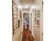 A hallway is decorated with a collection of framed photos and leads to a living space with a floral sofa and bookshelf at 33818 Venice Ln, Sorrento, FL 32776